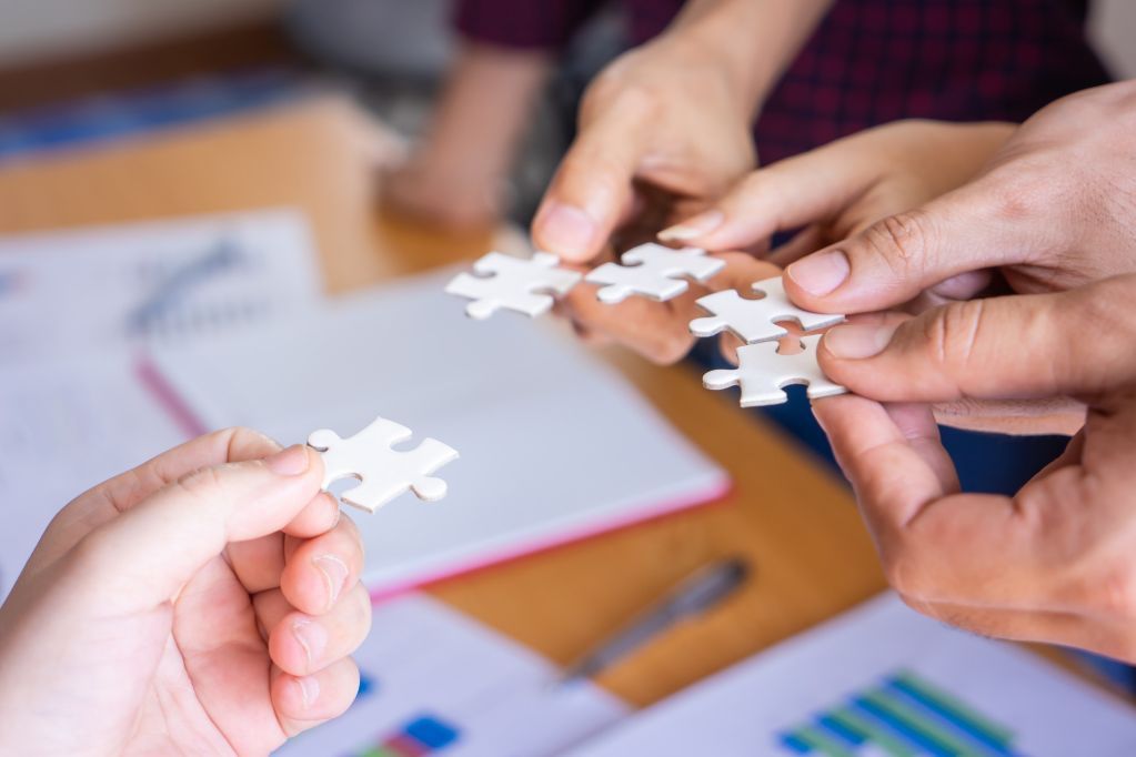 4 manos uniendo piezas de rompecabezas
